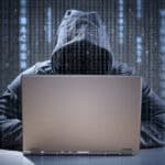 Computer hacker stealing data from a laptop